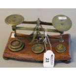 Set of brass letter scales with some brass weights, on a wooden base with bun feet. (B.P. 21% + VAT)