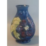Moorcroft Art Pottery tube lined blue ground 'Hibiscus' vase of baluster form. Impressed marks to