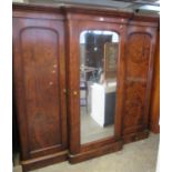 A Victorian walnut breakfront 3 door wardrobe, the central door revealing shelves and an arrangement