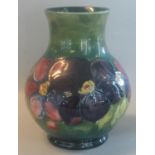 Moorcroft Art Pottery tube lined green ground 'Hibiscus' vase of baluster form impressed and painted