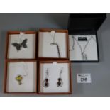 A collection of gem set silver jewellery comprising three pendants, Swarovski crystal pendant and