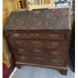 19th century oak and mahogany fall front bureaux ornately craved with flower heads and foliage on