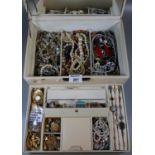 A large leather jewellery box containing costume jewellery and watches including a silver chain. (