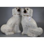 Two 19th century hand painted Staffordshire dogs in cream with black features, gilt highlights and