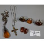 A collection of Amber and silver jewellery comprising three rings, a pair of clip on earrings and
