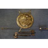 Repousse brass shield with pair of brass hilted, steel bladed swords, together with a stage prop