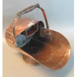 Copper helmet shaped coal scuttle with turned wooden swing handle. (B.P. 21% + VAT)