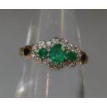 A three stone emerald and diamond ring set in 9ct gold. Ring size K&1/2. Approx weight 2.4 grams. (