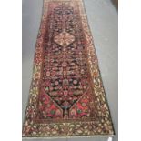 Middle Eastern design hand woven runner on a navy ground with central medallion and stylised flowers