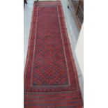 Middle Eastern design red and navy ground runner with central lozenge medallions and geometric