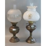 Two early 20th century double oil burner lamps on brass reservoir and bases. (2) (B.P. 21% + VAT)