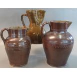 Two similar stoneware baluster single handled jugs, together with Ewenny style pottery single