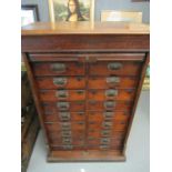 Early 20th century walnut and mahogany tambour straight front filing cabinet, having a bank of 18