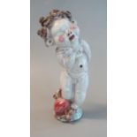 Glazed terracotta pottery figurine of a laughing Putti with tightly curled hair. Unmarked. 17.5cm