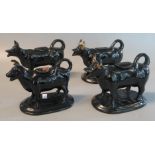 Four similar black ground cow creamers (B.P. 21% + VAT)