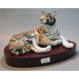 Large USSR porcelain study of a recumbent tiger on wooden oval base. (B.P. 21% + VAT)