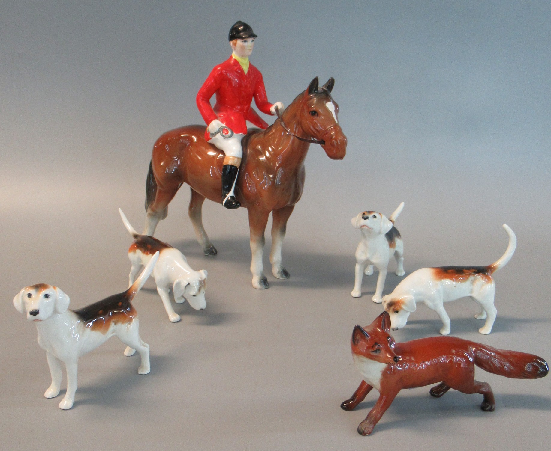 Beswick style huntsman in red jacket and black cap on horseback, together with four Beswick