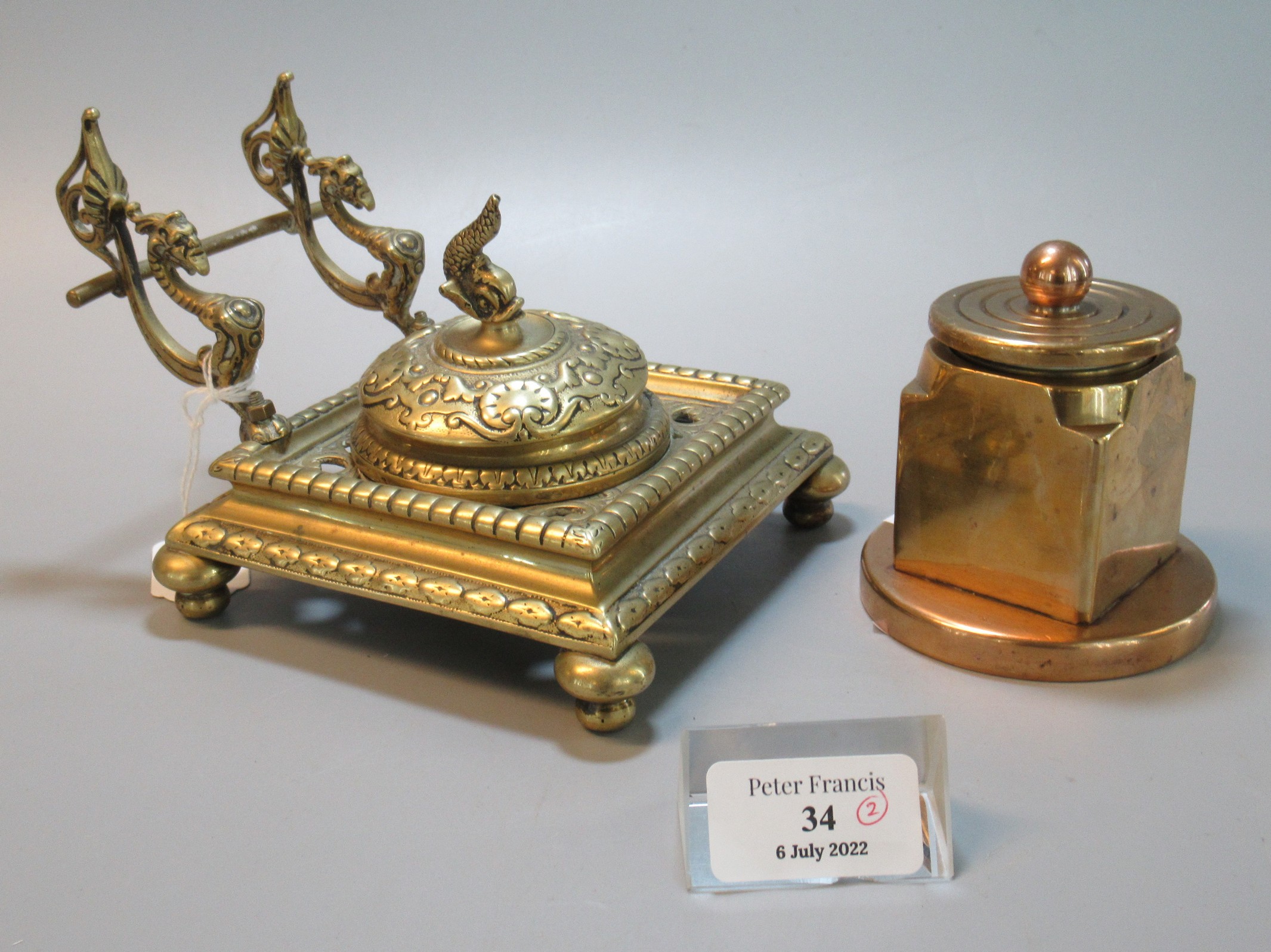 A Brass Gothic design single desk inkwell with grotesque and dolphin mounts, together with another