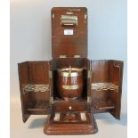 Early 20th century oak cigar cabinet with silver plated mounts, the interior revealing a tobacco jar