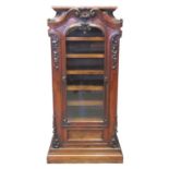 Early 19th century rosewood music sheet cabinet, the moulded top above a single glazed arched door