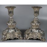 A pair of probably Danish silver filled candle sticks ornately decorated with moulded scrolls,