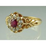 A Victorian oval ruby and diamond cluster ring in 18ct gold mount with engraved shoulders. Ring size