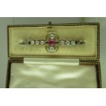 An early 20th century ruby and diamond brooch set in platinum fronted 15ct gold. The central ruby