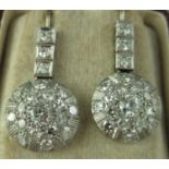 A pair of diamond Art Deco earrings the circular white metal drops set with a central old cut