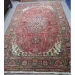 Middle Eastern design red ground multicoloured carpet having central medallion of flowers and