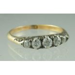 A five stone diamond ring, the old cut stones graduated from the centre in an 18ct gold mount.