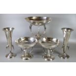 An Arts and Crafts hammered silver bowl garniture set of one large and two small bowls on stylised