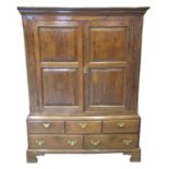 Early 19th century Welsh oak two stage blind panelled press cupboard, the moulded cornice above