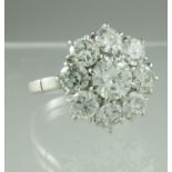 Diamond cluster ring of a central brilliant cut diamond surrounded by eight brilliant cut