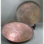 Two similar Turkish copper 'Tepsi' trays engraved with stylised flowers and foliage. 49cm diameter