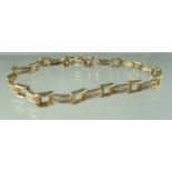A diamond line bracelet set in 9ct gold with safety clasp. Approx weight 10.8 grams. (B.P. 21% +