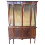 Late 19th century mahogany inlaid two stage bow front display cabinet, the moulded cornice above two