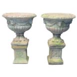 Pair of 20th century weathered composition garden Campana shaped urns having moulded lion mask
