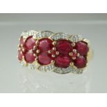 A double row ruby ring, the ten oval cut rubies interspersed with smaller circular rubies and