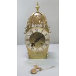 Dutch style brass lantern clock, having baluster finial above brass bell, pierced figural pediment