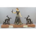 Art Deco design spelter group of a young lady holding a bird in her hand flanked by two leaping