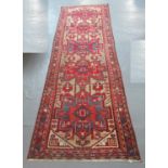 20th century Iranian runner on a blue, beige and red ground having five geometric medallions, the