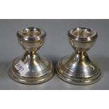 Pair of silver dwarf candlesticks with loaded bases, Birmingham hallmarks. 6cm high approx. (B.P.