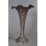 White metal trumpet or bud vase with loaded base, overall with palm trees, building and animals.