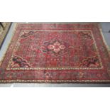 Middle Eastern design red ground carpet with central lozenge medallion flanked by flowers, foliage
