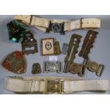 Collection of militaria to include; brass equipment protectors, belts, belt buckles, glass