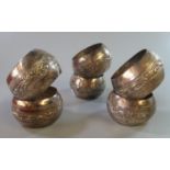 A set of six probably Indian silver (unmarked) baluster shaped scroll decorated napkin rings.