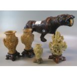 Three Oriental carved soap stone baluster shaped vases with relief foliate decoration on stands.,