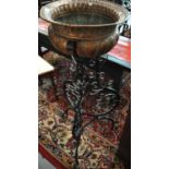 Arts & Crafts design copper and verdigris baluster planter standing on a wrought iron scroll