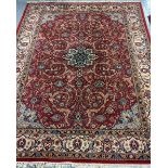 Middle Eastern design red ground carpet decorated with multicoloured flower heads and foliage with