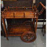 Unusual Indian hardwood and brass inlaid two tier drinks trolley on eight spoke wheels. (B.P.